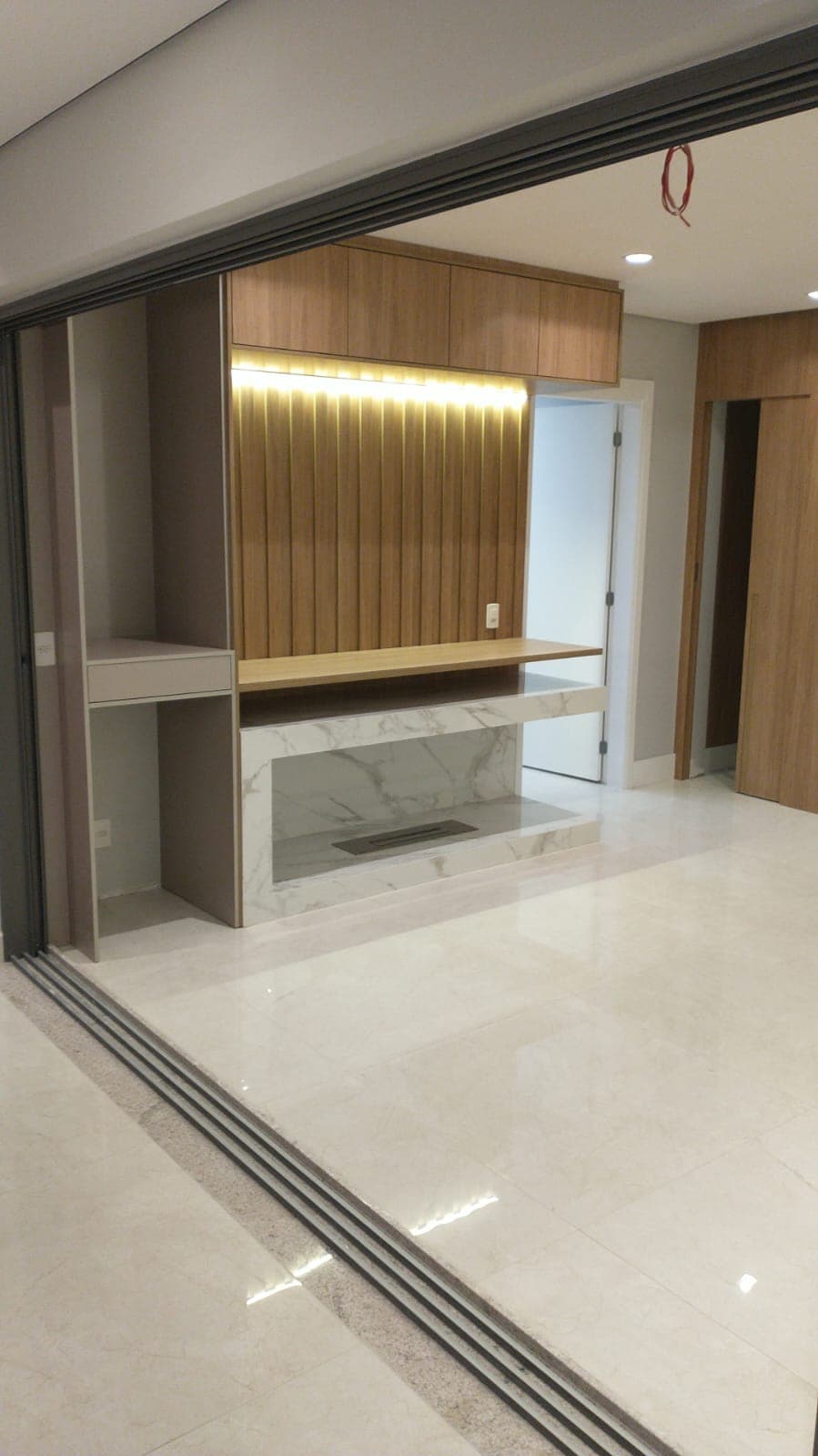 Ambiente residencial com painel de marcenaria, bancada e revestimento em acabamento.